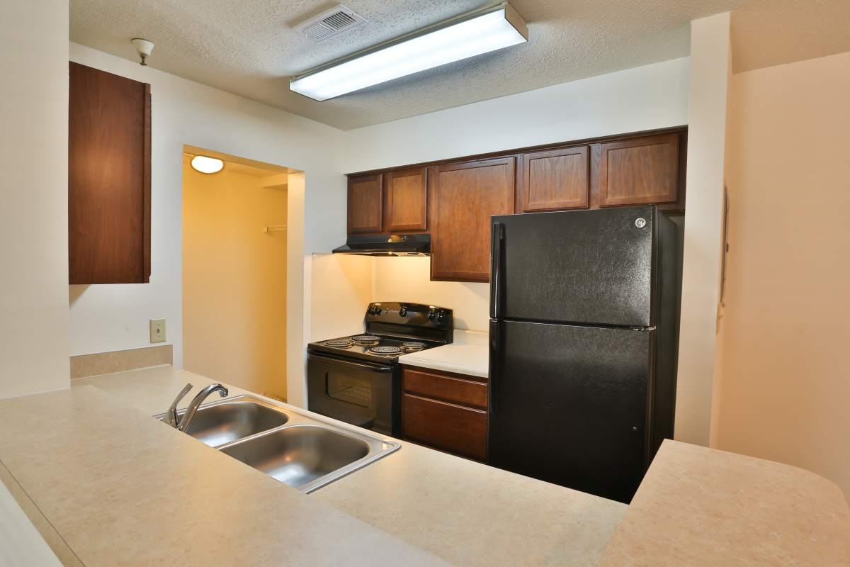 Cozy kitchen with a white countertop and black-colored appliances including refrigerator at Chickahominy Bluff in Mechanicsville, Virginia