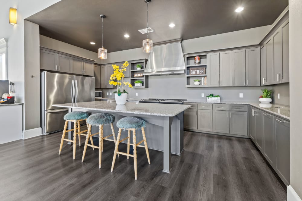 Hardwood flooring and granite countertops in a model home's kitchen at Carrington Oaks in Buda, Texas