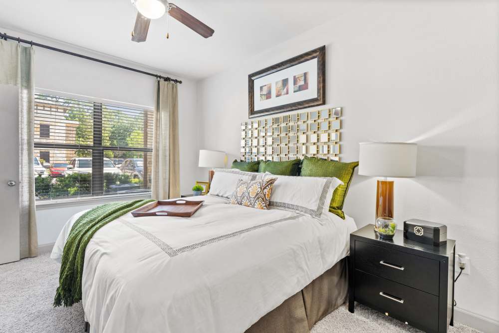 Comfortable bedroom with king size bed, ceiling fan and large window at The Abbey at Preserve Way in Tomball, Texas
