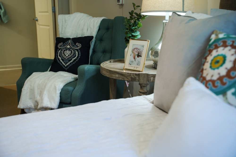 Close up of bedroom with bed and arm chair at Harmony on the Peninsula in Yorktown, Virginia