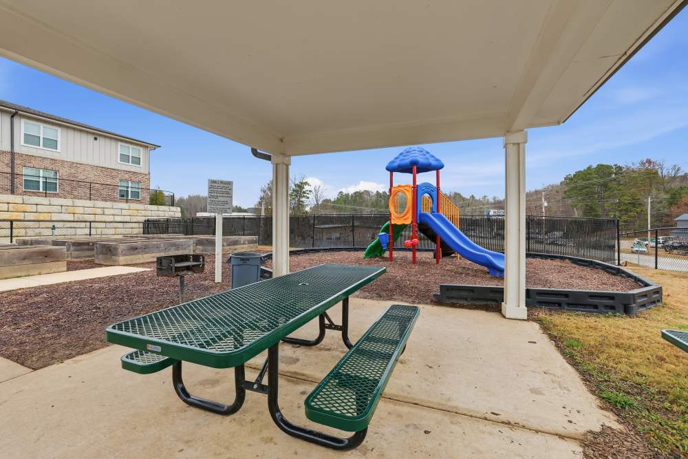 Playful playground with vibrant equipment and sheltered picnic area at Flats At Sam Lane in Ringgold, Georgia.