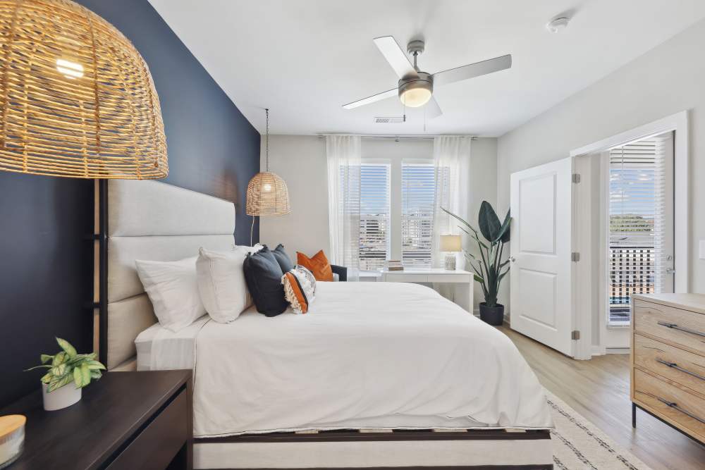 Spacious bedroom with large comfortable bed, ceiling fan and large glass windows at  Mosby Bridge Street in Huntsville, Alabama