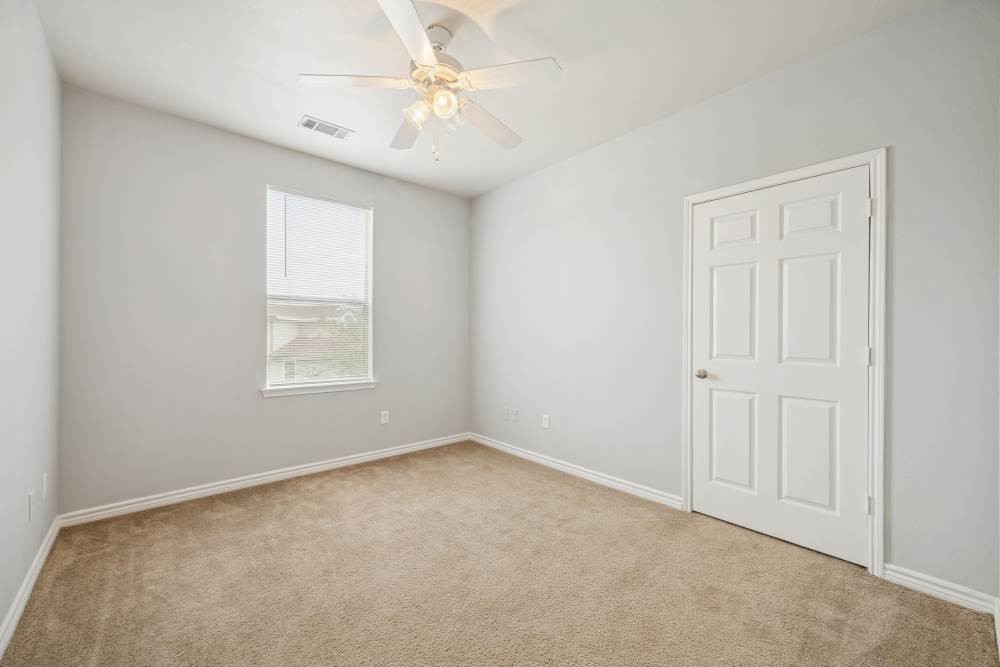 Bedroom with carpet flooring, door and window at The Cove at Palmer Point in Texas City, Texas