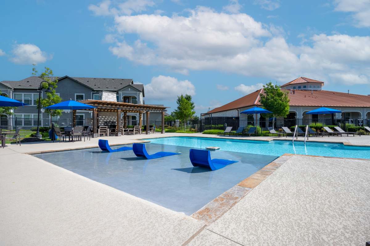 Swimming pool with sun bed and lounge chairs at Century Travesia in Austin, Texas