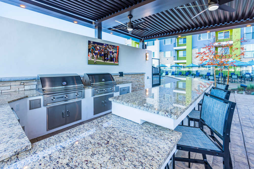 BBQ grill area with granite countertop and barstool at Zeta Luxury Apartments in Sacramento, California