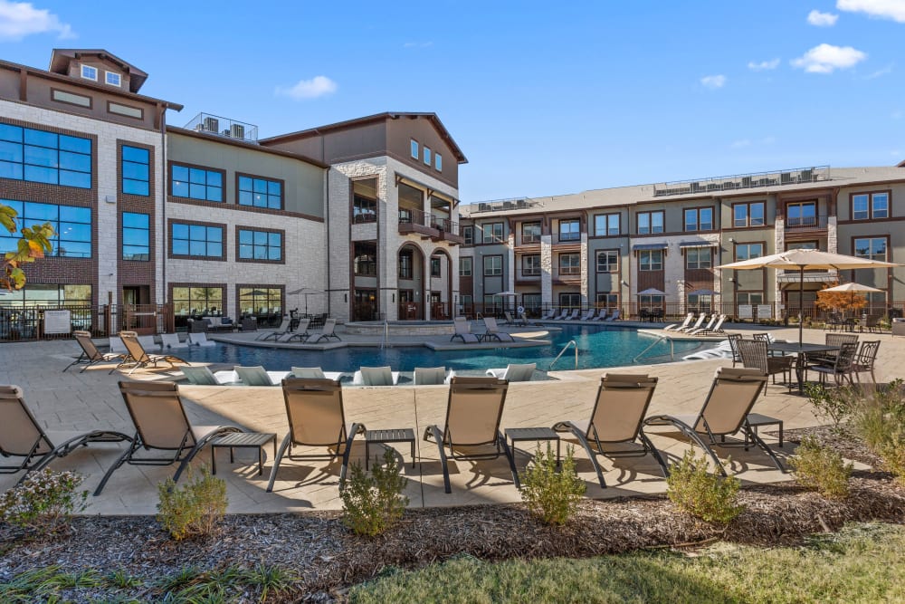 Resort style pool with lounge seating and bright sunny deck at Olympus Hudson Oaks in Hudson Oaks, Texas