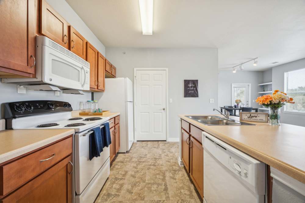 Bright kitchen with fully equipped with white appliances at The Cove at Palmer Point in Texas City, Texas