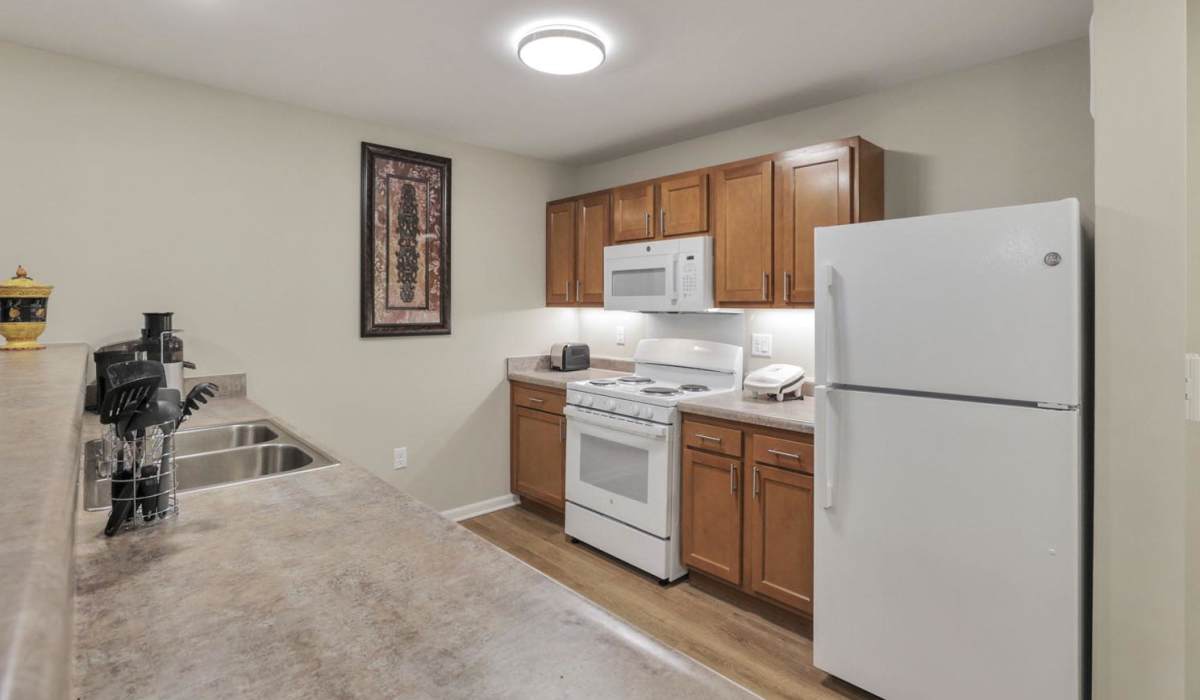 Kitchen with wooden cabinets and a dishwasher at McKinley Manor in Columbus, Ohio