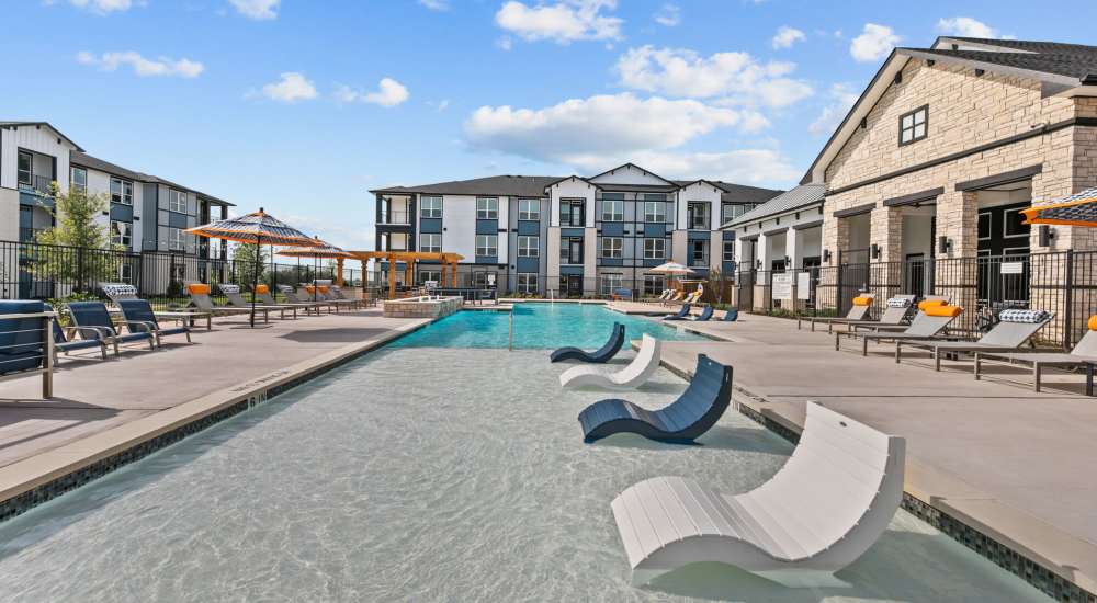 Resort style swimming pool with lounge area at The Summit at Walnut Creek in Alvarado, Texas