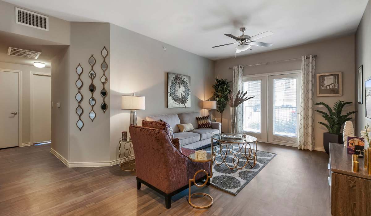 Living room with large couch, chair, ceiling fan and windows at Canyon House in New Braunfels, Texas
