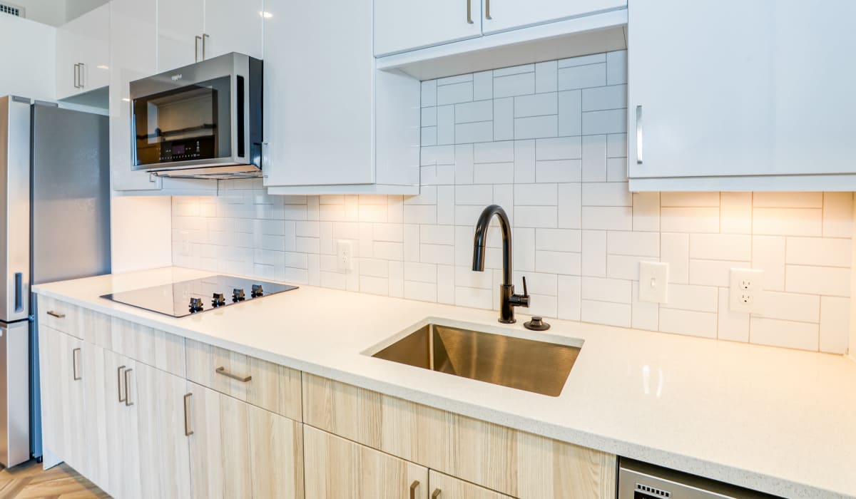 Kitchen with tile backsplash and wooden cabinetry at Accent LoHi in Denver, Colorado