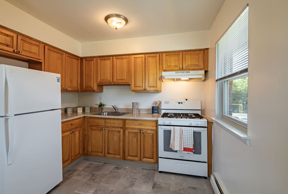 Kitchen with maple cabinets and white appliances at Glen Ellen Apartment Homes in Long Branch, New Jersey