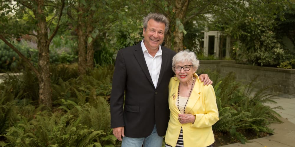 A staff member posing for a picture with a resident at Merrill Gardens at Tacoma in Tacoma, Washington. 