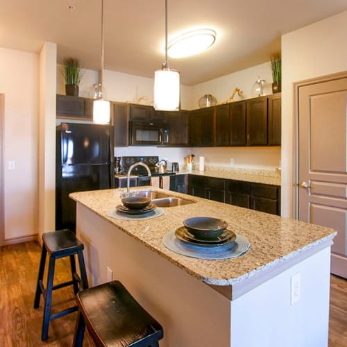 Gourmet kitchen with an island and granite countertops in a model home at Anatole on Briarwood in Midland, Texas