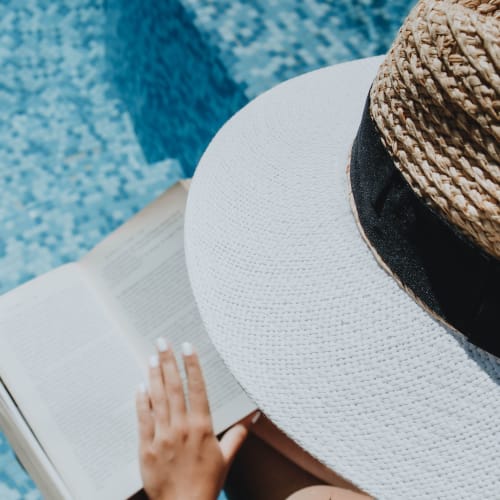 Reading by the pool at Arborgate Apartments Homes in Charlotte, North Carolina