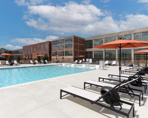 Sparkling pool with seating area at Mojud Lofts in Greensboro, North Carolina