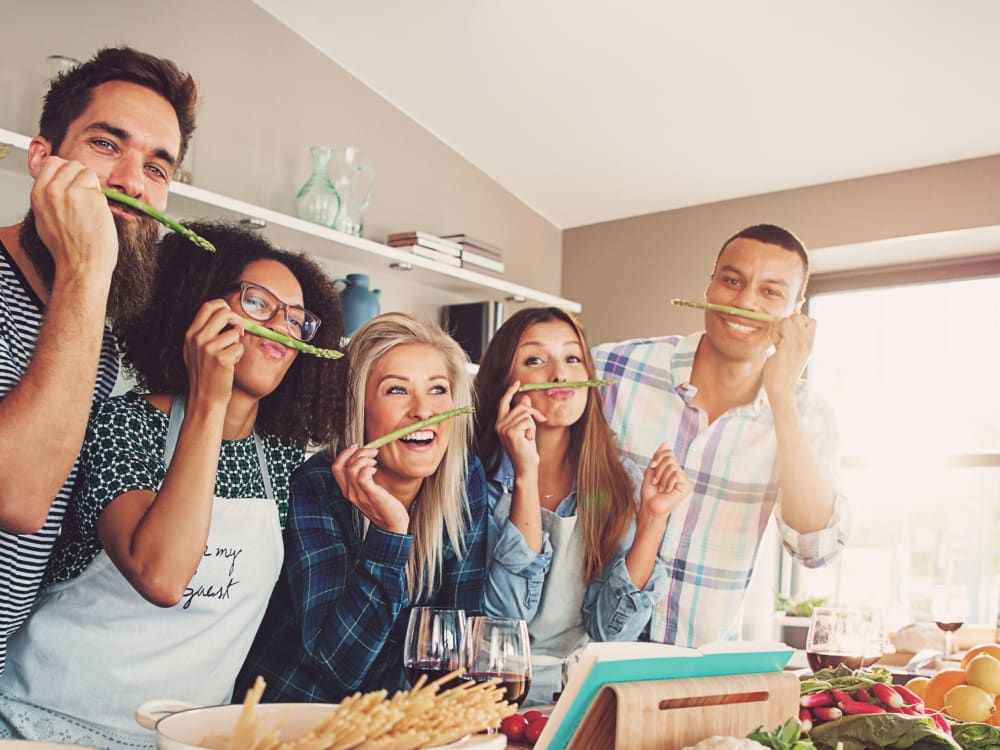 Resident friends goofing around while cooking pasta together at Terra Apartment Homes in Federal Way, Washington