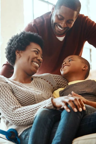 A couple smiling with child at The Towne at Northgate Apartments in Colorado Springs, Colorado