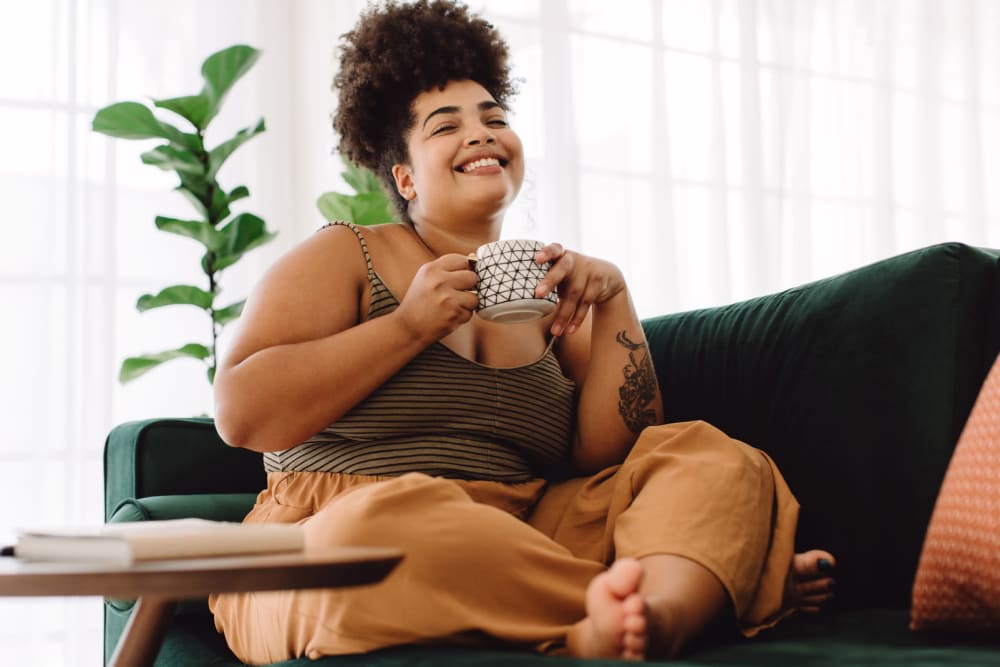 Resident smiling on the couch of her apartment at Lehigh Square in Allentown, Pennsylvania