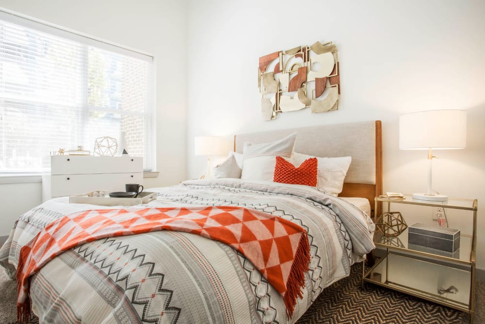 Bright and comfy bedroom with full size bed, dresser, and side tables at Marq Midtown 205 in Charlotte, North Carolina