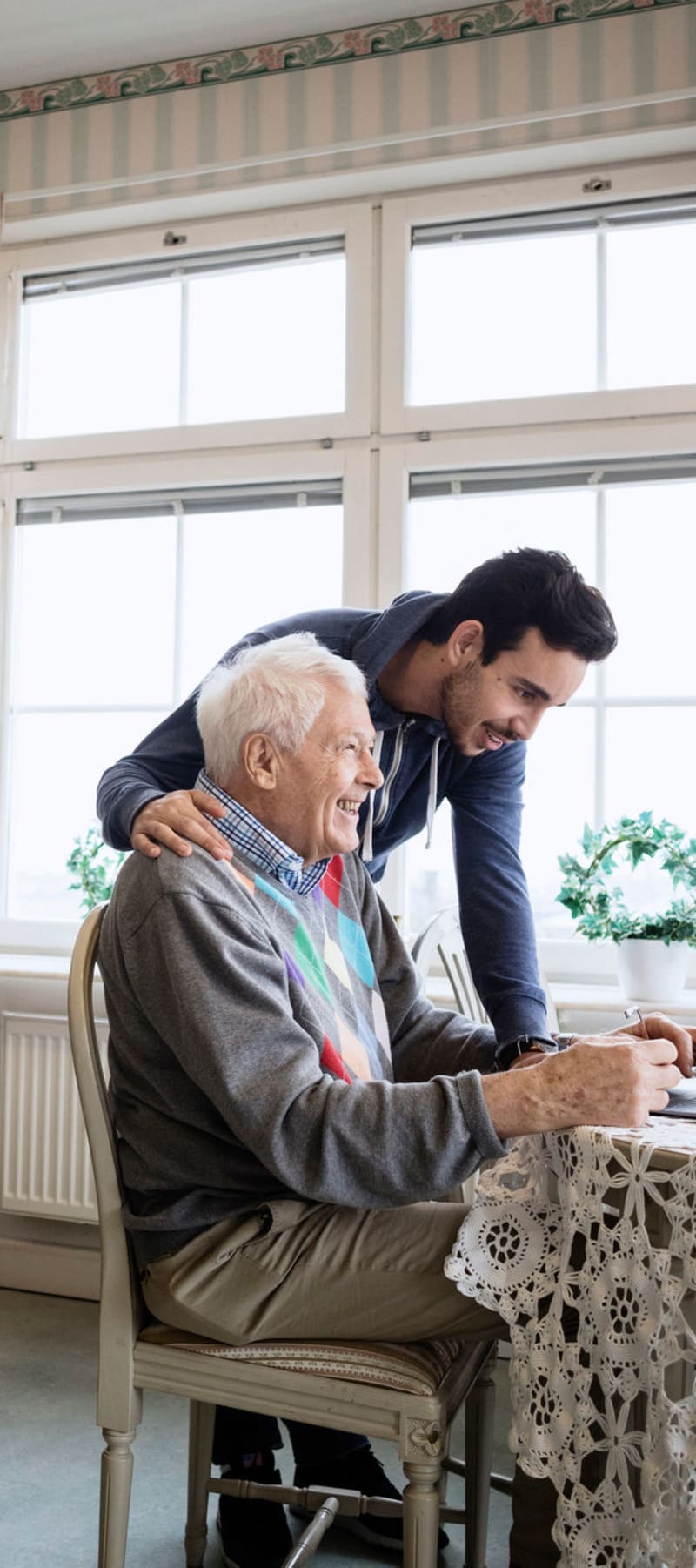 Resident on a laptop being assisted by a caretaker at Fair Oaks Health Care Center in Crystal Lake, Illinois