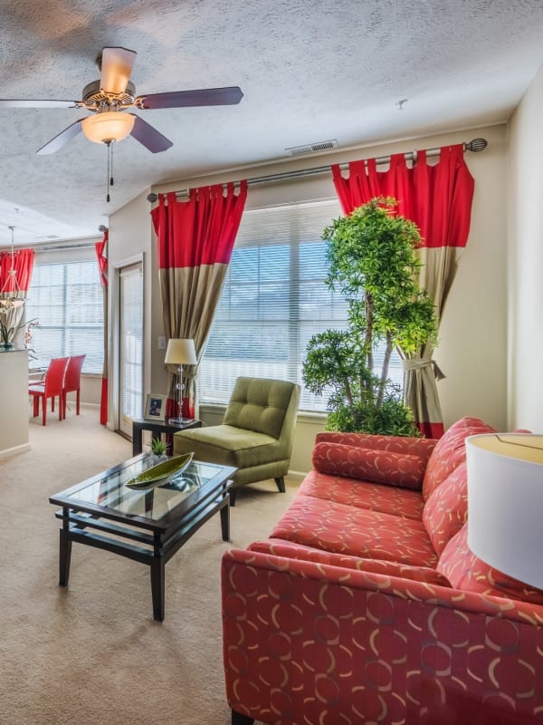 Model living room with a ceiling fan and wall-to-wall carpeting at Westlake at Morganton in Fayetteville, North Carolina