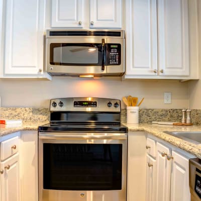 Gourmet kitchen with stainless-steel appliances and bright white cabinetry in a model home at Sofi Berryessa in San Jose, California