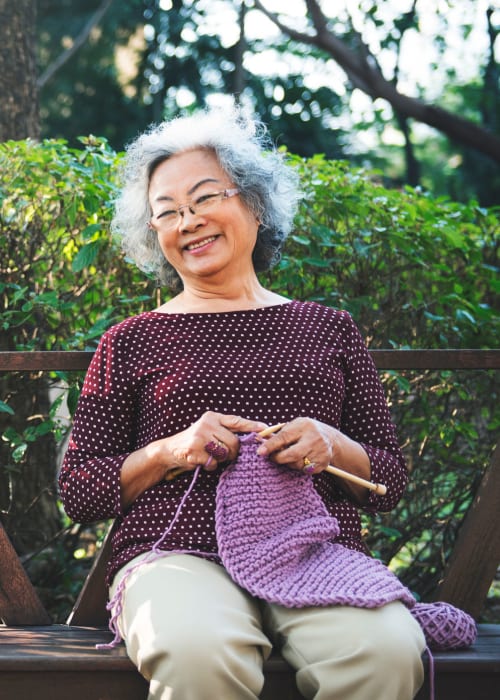 Resident knitting outdoors at Grand Villa of Altamonte Springs in Altamonte Springs, Florida