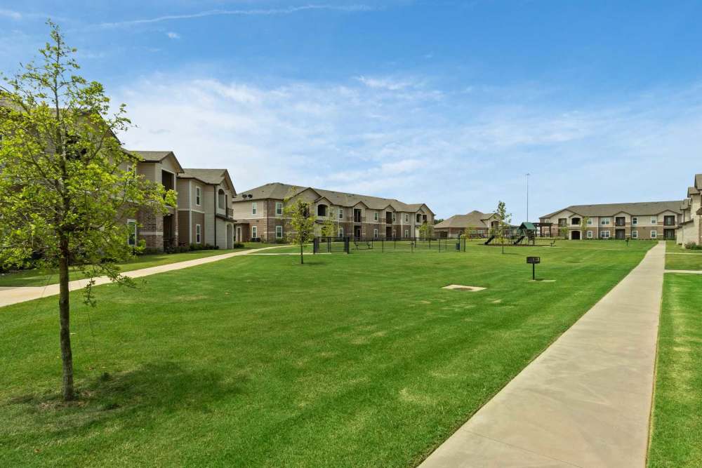 Lush manicured landscaping with fenced dog park at Pine Creek in Paris, Texas