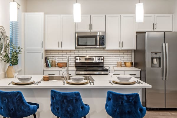 Open kitchen area with three chairs displaying at front at Ravello 192 in Elkhorn, Nebraska