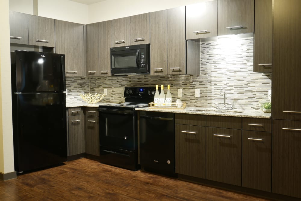 Kitchen with black appliances at Terra at University North Park in Norman, Oklahoma