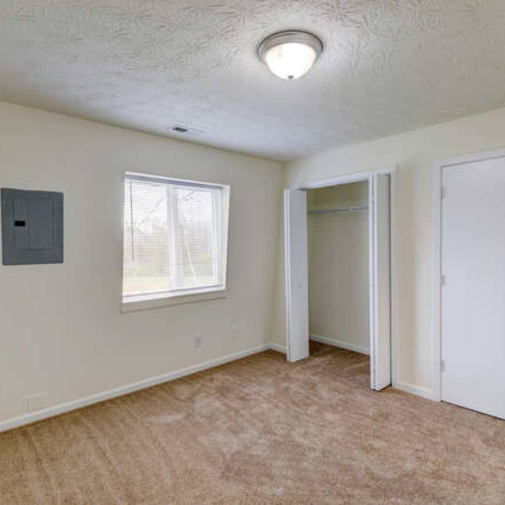 A spacious bedroom with closet and large window at Cumberland Manor in Indianapolis, Indiana