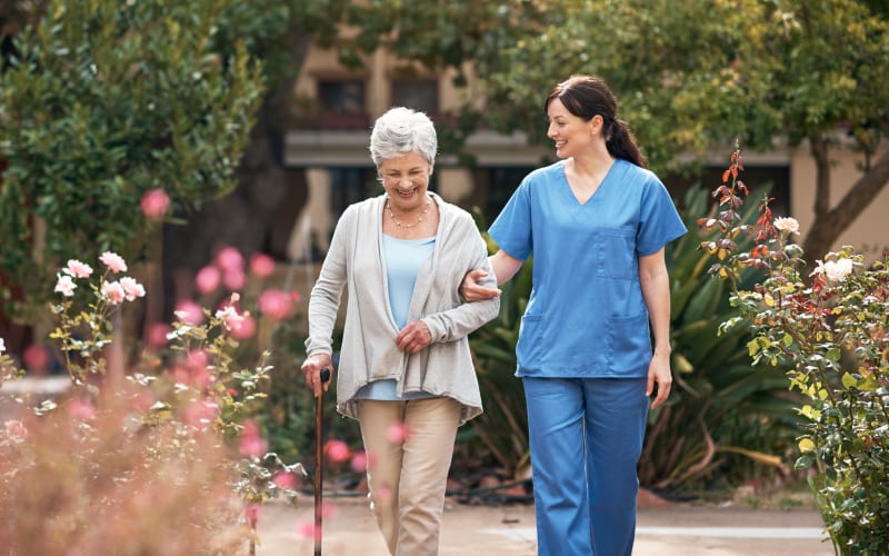 Resident walking with a caretaker outside at a Living Care Lifestyles community