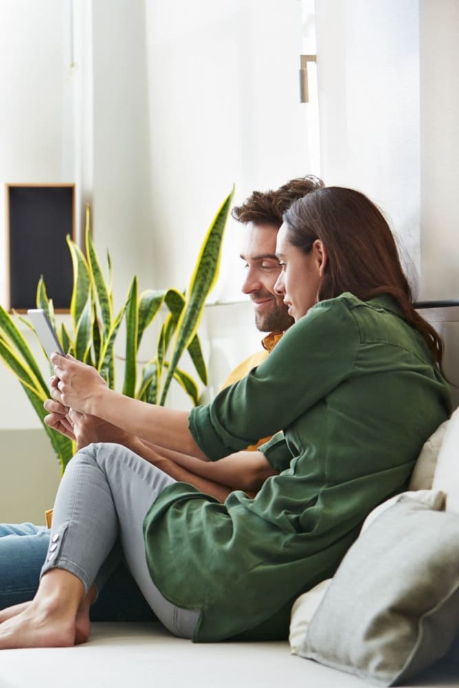 Couple seating on the couch in a model apartment at Aspen Plaza in Albuquerque, New Mexico