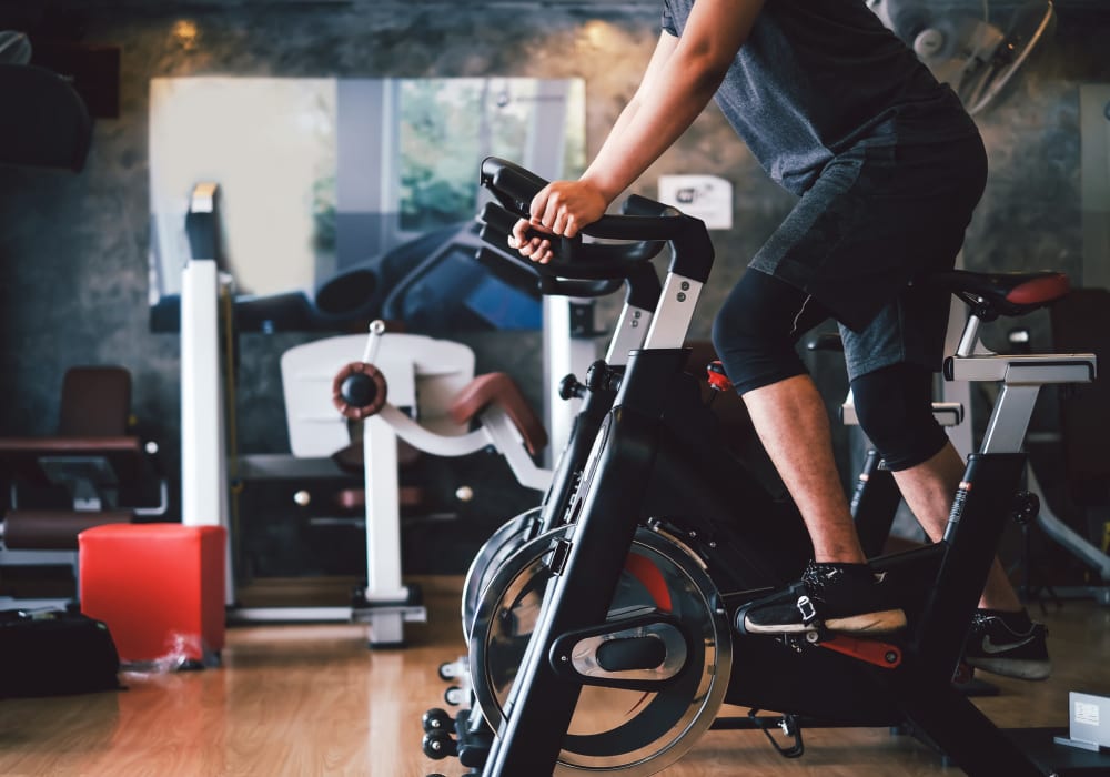 Resident enjoying a bike workout at The Abbey at Energy Corridor in Houston, Texas