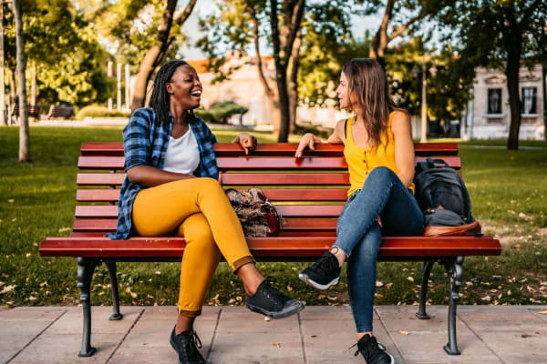 Two residents sitting on a bench at a park near BB Living at Civic Square in Goodyear, Arizona