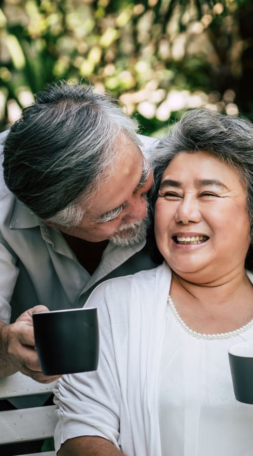 Resident couple sitting outside drinking coffee at Jaybird Senior Living