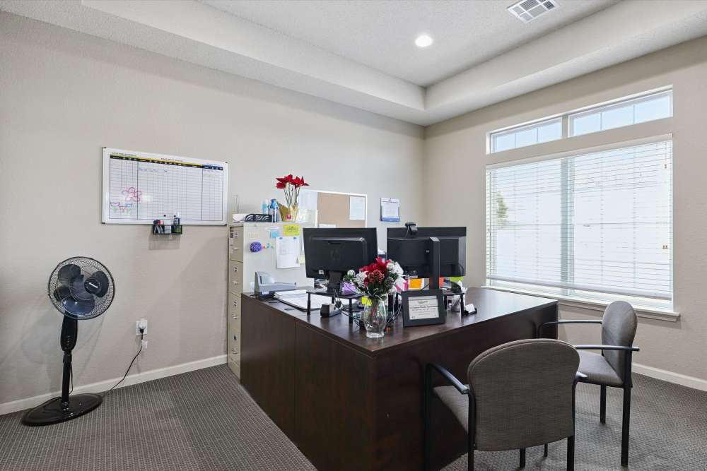 Cozy and functional office space featuring a modern desk setup and bright natural light at Covington Woods Apartments in Lansing, Kansas.