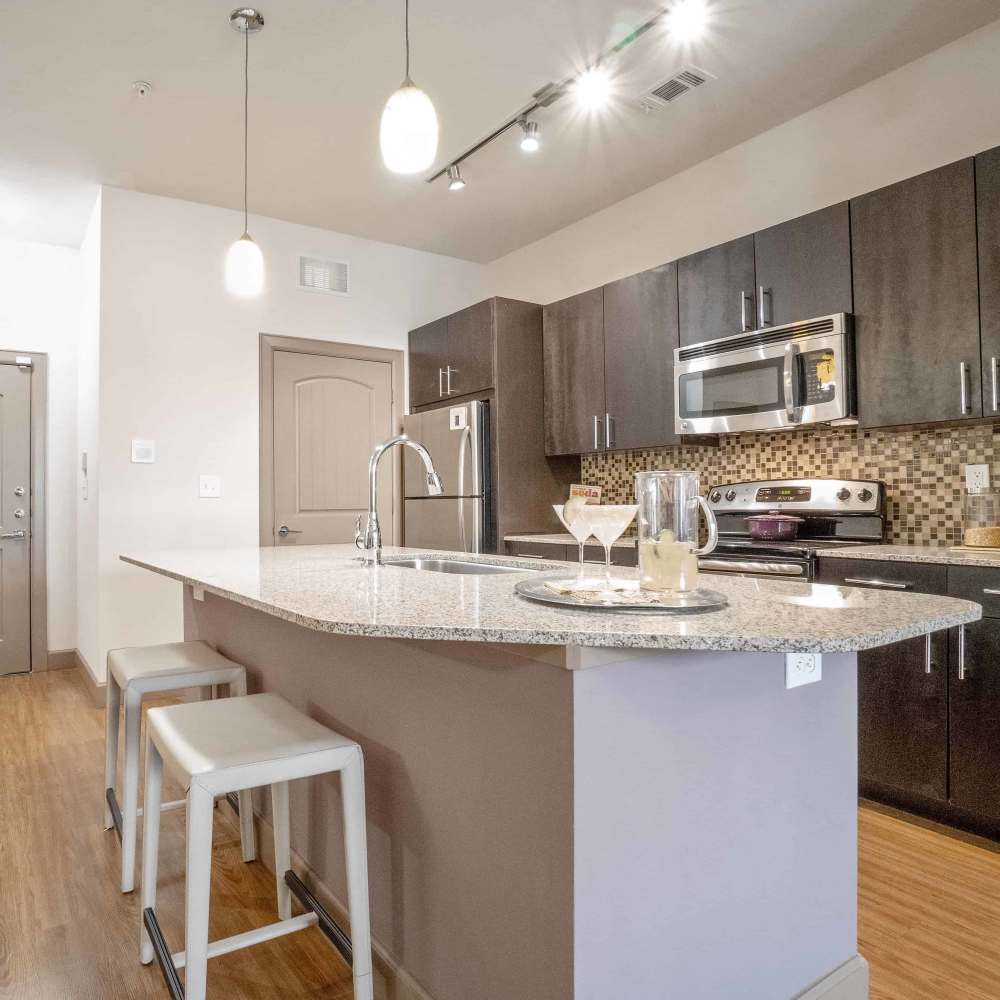 Apartment kitchen with a breakfast island at Grapevine Station in Grapevine,Texas