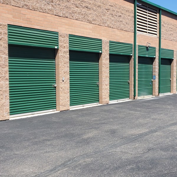 Outdoor storage units with green doors at StorQuest Self Storage in Aurora, Colorado
