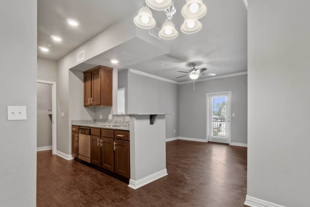 Stained custom cabinetry and wood flooring in the apartment at Pine Creek in Paris, Texas