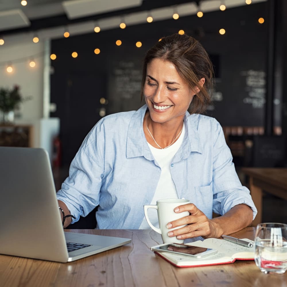 Resident getting some work done on her laptop at a café near Oaks White Rock in Dallas, Texas