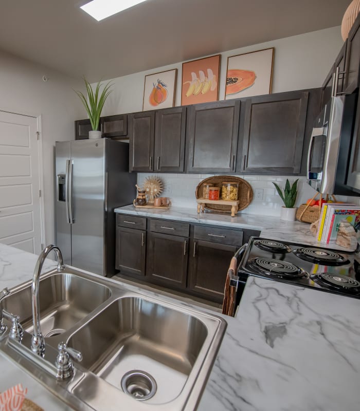 Kitchen with marble counters and stainless-steel appliances at Adirondack in Independence, Missouri