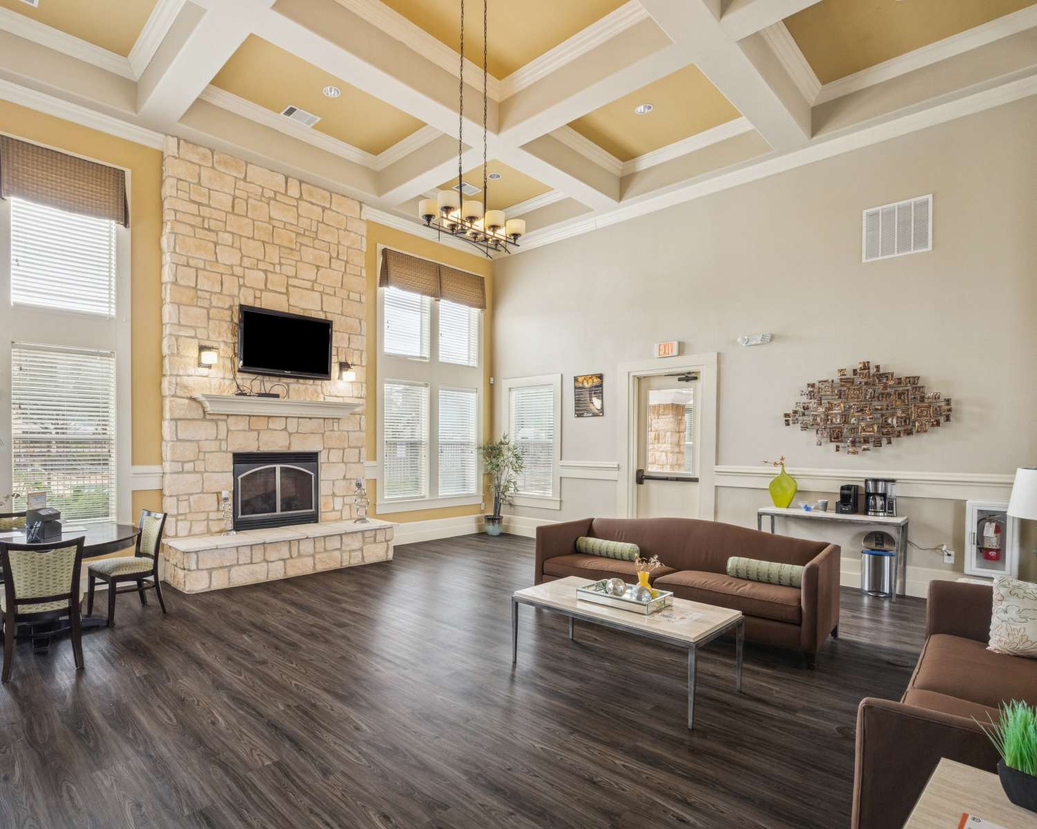 Apartments clubhouse with couch, fireplace and dining at The Cove at Palmer Point in Texas City,Texas