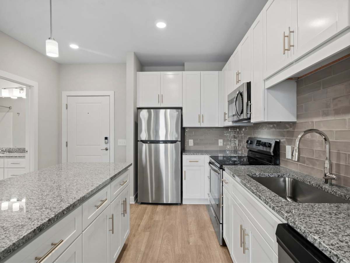 Kitchen with stainless-steel appliances and granite countertop at The Rise at Regency in Henrico, Virginia