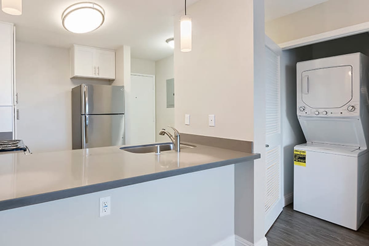 Kitchen with stackable washer and dryer nearby at The Avenue at Carlsbad in Carlsbad, California