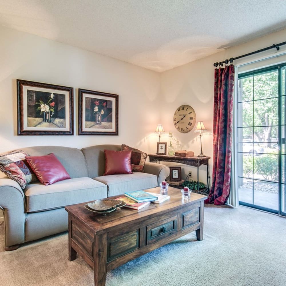 Living room with plush carpeting and balcony access at Springhill Apartments in Overland Park, Kansas