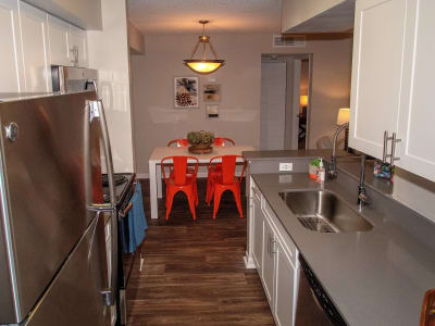 An apartment kitchen and dining table at Onyx Winter Park in Casselberry, FL