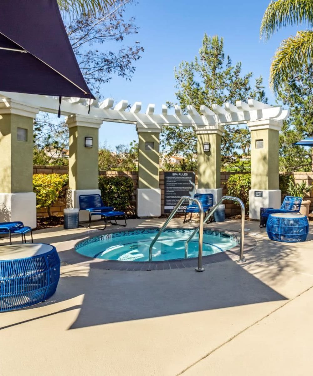 Picnic tables under a pergola with nearby gas barbecue grills at Sofi Highlands in San Diego, California