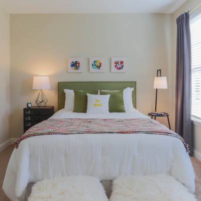 A cozy bedroom featuring a neatly made bed at Gallatin Commons in Gallatin, Tennessee